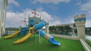 Ein Spielplatz mit Rutschen und Burg-ähnlichen Bauwerken.