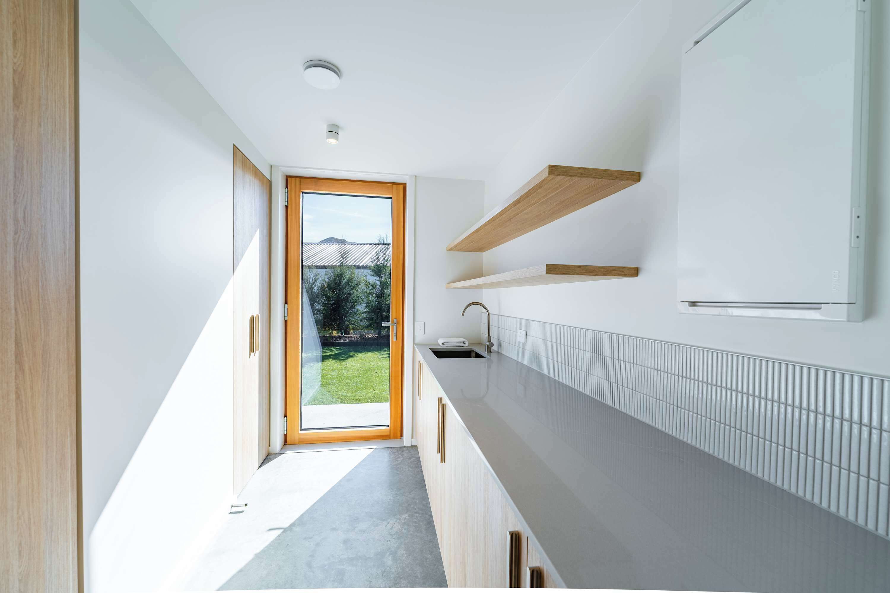 Una cocina moderna con horno integrado, un lavamanos y ventana con vistas a un jard ín.