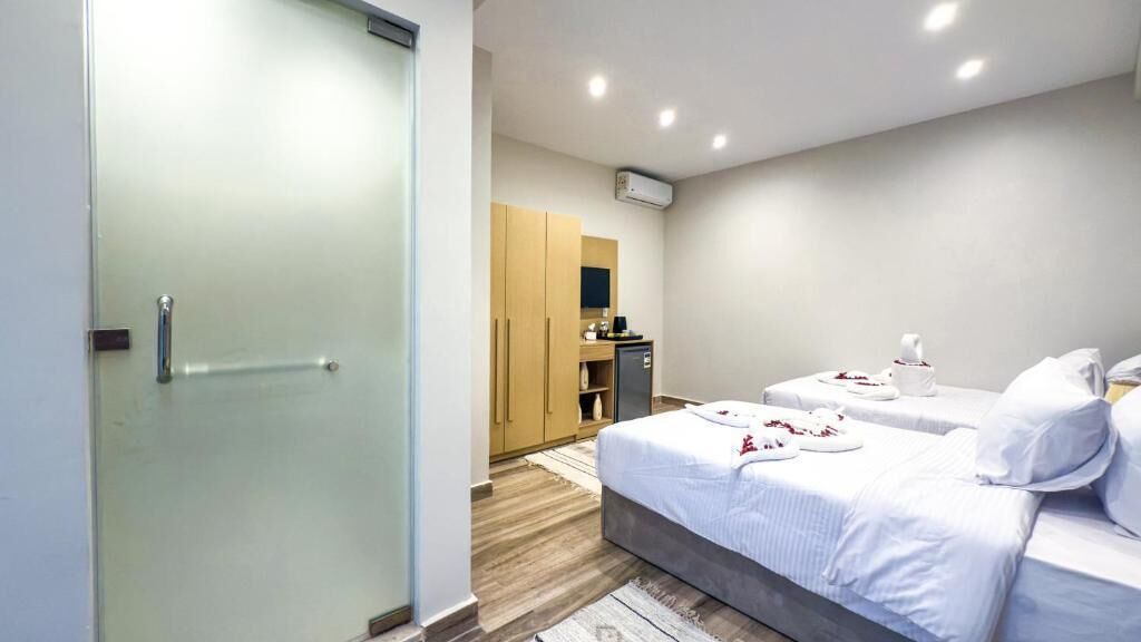 A hotel room with a bed, a desk, a wardrobe, and a bathroom.