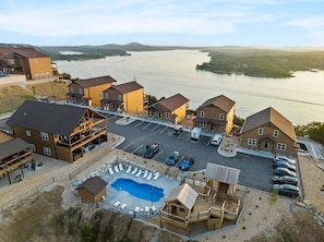 A resort with a swimming pool, multiple buildings, and a view of a lake. - View of Outdoor Pool&Table Rock_Arcades_Pvt Hot Tub_Shuffleboard_Free Tickets (Kimberling City)