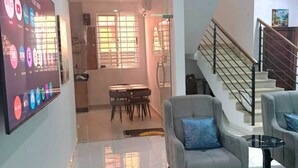 Uma sala de estar moderna com um sofá, uma mesa de centro e uma escadaria que dá para outro andar.