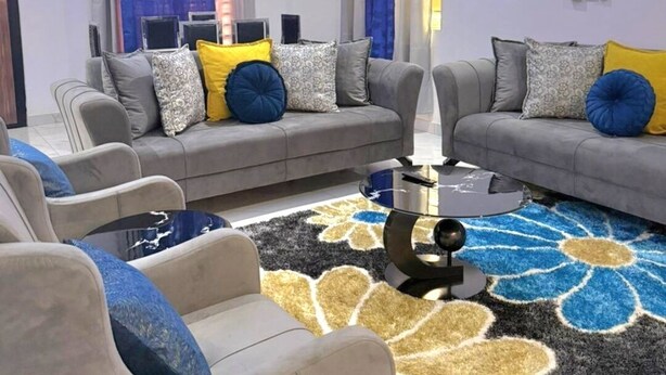 Uma sala de estar moderna com um sofá, uma mesa de centro e um tapete decorativo.