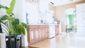 Cozinha moderna com armários de madeira, fogão branco e um vaso de planta.