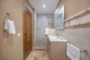 A bathroom with a wooden door, a sink with a mirror, and a shower area. - Hacienda El Legado 4 Apartment with Shared Pool, Wi-Fi & Air Conditioning (Chiclana de la Frontera)