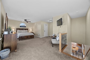 A bedroom with a bed, a desk, a chair, a TV, and a ceiling fan. - Lodge style, 4 bedroom home on Lamoka Lake (Bradford)