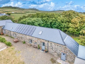 A stone building with a sloped roof and solar panels. - Old Spot Cottage, Holiday Cottage Strumble Head Peninsula, Sleeps 6, 3 bedrooms,  bathrooms (Goodwick)