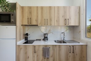 A modern kitchen with wooden cabinets, a microwave, a coffee maker, and a sink. - Vacation Home 'Casa 4' with Mountain View, Wi-Fi and Air Conditioning (Taidía)