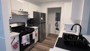 Eine moderne Küche mit Herd, Backofen, Kühlschrank und Mikrowelle.