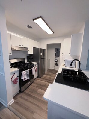 A modern kitchen with a stove, oven, refrigerator, and a microwave.