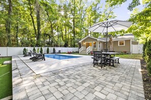 A backyard with a swimming pool, patio furniture, and a house. - The Hidden Gem in North Myrtle Beach (North Myrtle Beach)