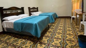 A room with two beds, a small table, and a chair. - Hotel Malybu (Guatemala City)