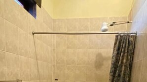 A small bathroom with a toilet, a shower area, and a sink. - Hotel Malybu (Guatemala City)