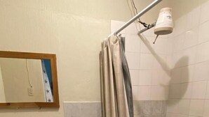A bathroom with a toilet, sink, shower, and a mirror on the wall. - Hotel Malybu (Guatemala City)
