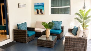 A room with a 'BEACH' sign, wicker furniture, a potted plant, and a view of the ocean through a window. - 3 bedroom, 2 full baths, with private pool, barbecue and  pet designated a (Oakland Park)