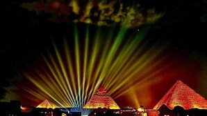 A pyramid illuminated by colorful lights. - pyramids Moon IIn (Giza)