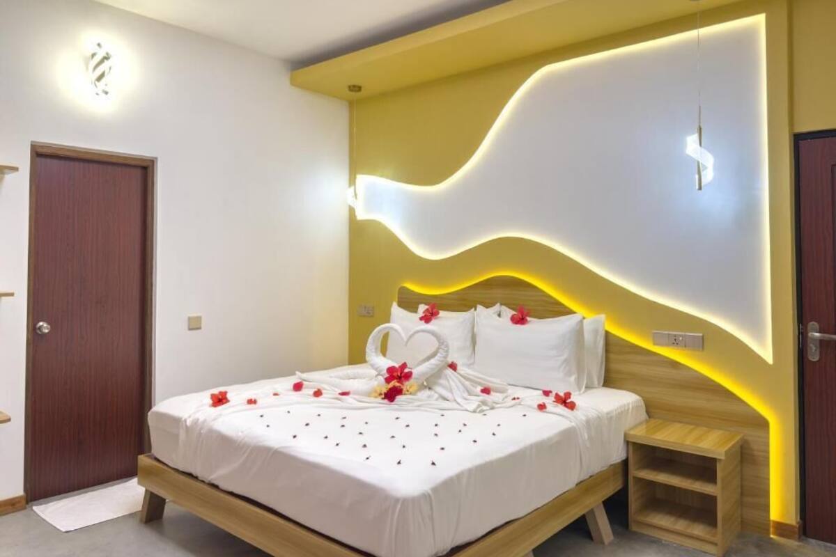 Een moderne slaapkamer met een bed, nachtkastje en een uniek ontwerp aan de muur.