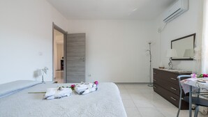 Ein Hotelzimmer mit Bett, Schreibtisch, Kommode und Klimaanlage.