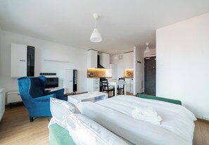 Habitació d'hotel moderna amb llit, escriptori, cadira, televisió i armari.