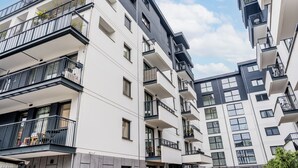 A multi-story residential building with balconies, large windows, and a modern architectural design. - Wilczak 16A Cosy Studio (Poznań)