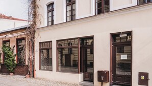 A building with large windows, a door marked with the number 14, and a mailbox. - Apartament Ceglane Studio (Toruń)