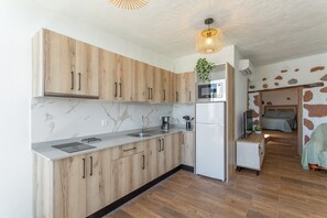 Une cuisine moderne avec des meubles en bois, un plan de travail en marbre et un four à micro-ondes encastré.