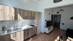 Eine moderne Küche mit Holzausziehtüren, einer Marmor-Spritzschutzwand und einem integrierten Kühlschrank.