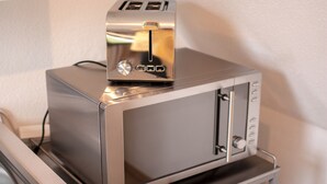 Ein kleiner, metallener Toasterofen mit Bedienfeld und einer einzelnen öffnung für Brot.