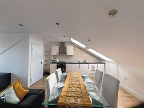 A modern apartment with a dining area, kitchen, and a loft bedroom. - Spacious Apartment Sleeps 7 near central London (Greater London)