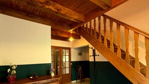 A wooden staircase with a handrail, a wooden cabinet with drawers, and a tiled floor.