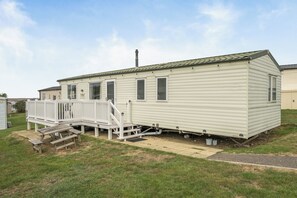 Una casa mobile a un piano con veranda anteriore e piccolo portico.