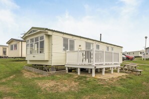 Una casa mobile a piano terra con un portico e una piccola terrazza.