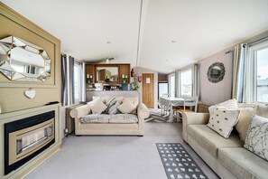 A compact living space with a sofa, a dining table, and a kitchen area.