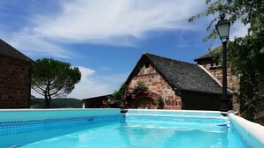 A swimming pool with a stone building in the background. - Guest Room “Beaucaire” with Shared Pool, Garden, and Wi-Fi (Nauviale)
