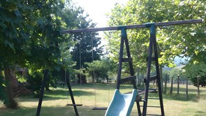 A playground with a slide and swings. - Guest Room “Beaucaire” with Shared Pool, Garden, and Wi-Fi (Nauviale)