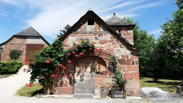 A stone building with a pitched roof, a central archway, and a small staircase leading up to the entrance. - Guest Room “Beaucaire” with Shared Pool, Garden, and Wi-Fi (Nauviale)