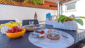 A table set with various food items, a bowl of strawberries, a basket of fruits, and a bottle of juice. - ‘Trifamiliare Garden - Sole’ Apartment with Private Terrace, Wi-Fi, and Air Conditioning (Agnone)