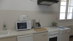 Una cocina equipada con microondas, cafetera y horno.