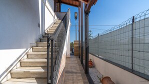 A narrow outdoor corridor with a staircase, a metal fence, and a clear blue sky. - Seaside Apartment 'Trifamiliare Garden - Conchiglia' with Private Terrace, Wi-Fi & AC (Agnone)