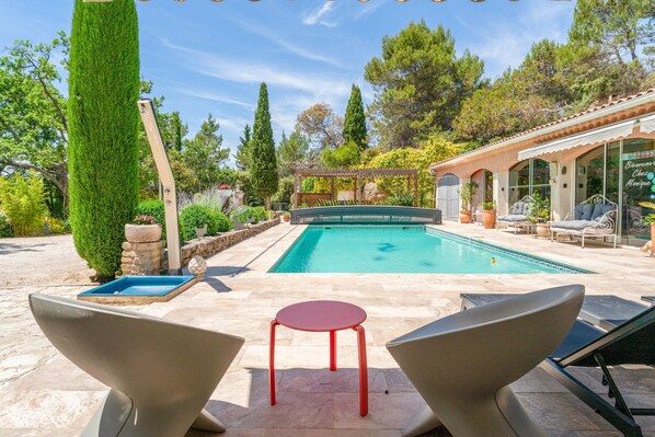 A pool area with a pergola, lounge chairs, and a small table. - Bed and Breakfast 'Chambre Saumon' with Shared Pool, Wi-Fi and Air Conditioning (Bédoin)