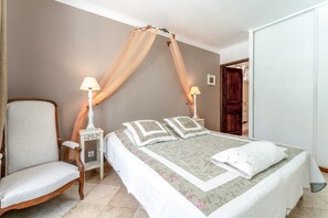 A bedroom with a bed, a chair, a nightstand, and a canopy. - Bed and Breakfast 'Chambre Saumon' with Shared Pool, Wi-Fi and Air Conditioning (Bédoin)