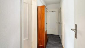 A narrow hallway with white walls, a wooden wardrobe, and a white door at the end. - Apartment “Central Hemer Near Lung Clinic” with Wi-Fi (Hemer)
