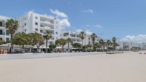 A beachfront hotel with multiple floors, palm trees, and a sandy beach. - Apartment 'Marítimo' with Sea Views and Private Terrace (Barbate)