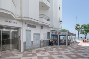 Ein Gebäude mit einem Schild, auf dem 'EDF MARITIMO B' steht, und ein Restaurant namens 'Cia Rita' mit Außenbereich.