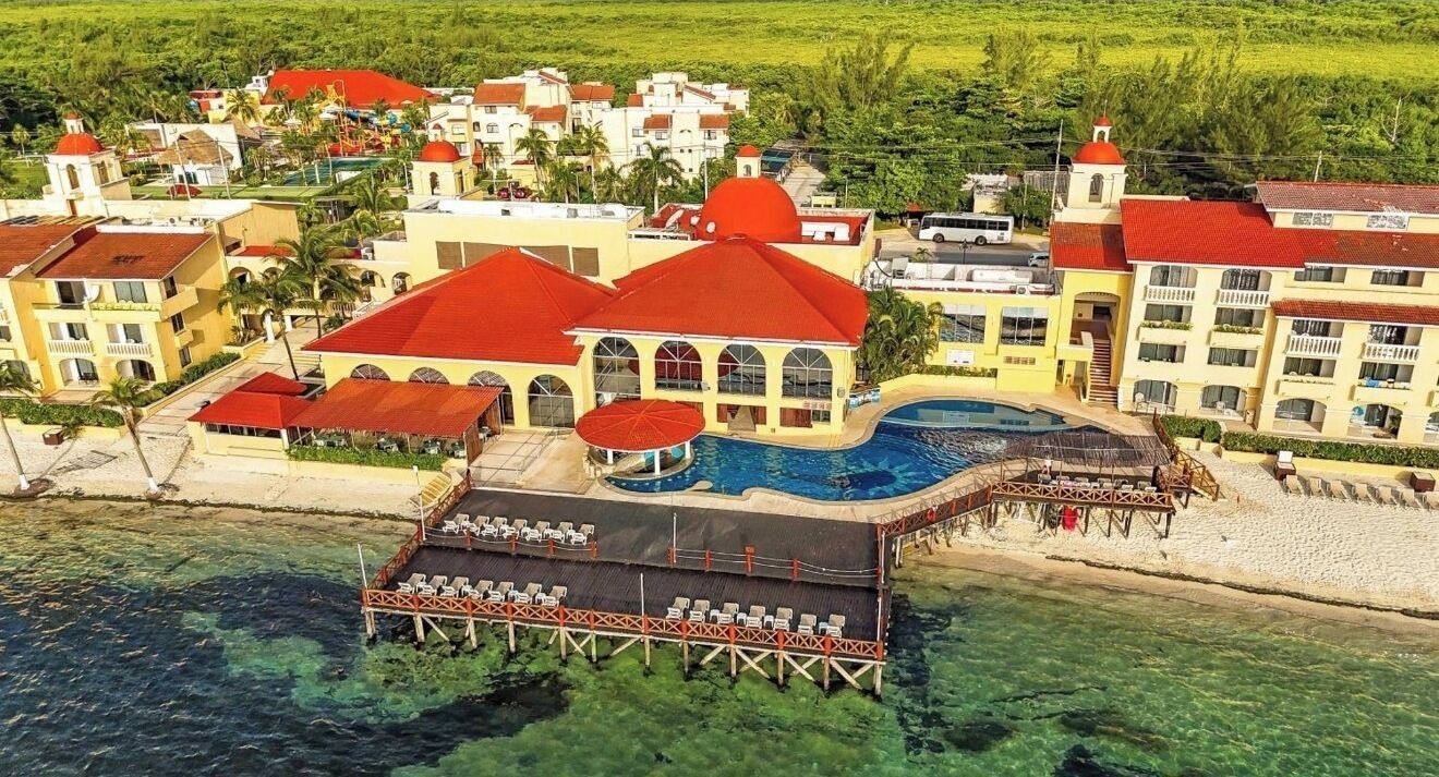 Un complejo turístico con piscina, zona techada y muelle sobre el agua.