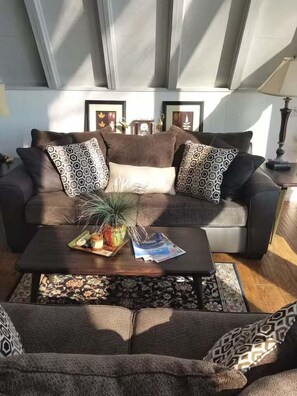 A modern living room with a sofa, coffee table, and decorative pillows.