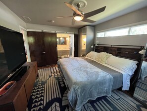 A hotel room with a bed, a television, a ceiling fan, and a window. - Split King adjustable bed, fish pond and huge fenced in yard - 1 mile to CSU (Fort Collins)