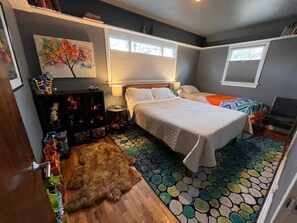 A bedroom with a bed, a rug, a shelf with toys, and a painting on the wall. - Split King adjustable 3 bed 2 bath - 1 mile to CSU (Fort Collins)