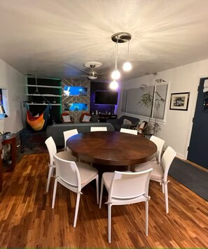 A dining area with a round table and white chairs, a ceiling fan, and a TV mounted on the wall. - Split King adjustable 3 bed 2 bath - 1 mile to CSU (Fort Collins)
