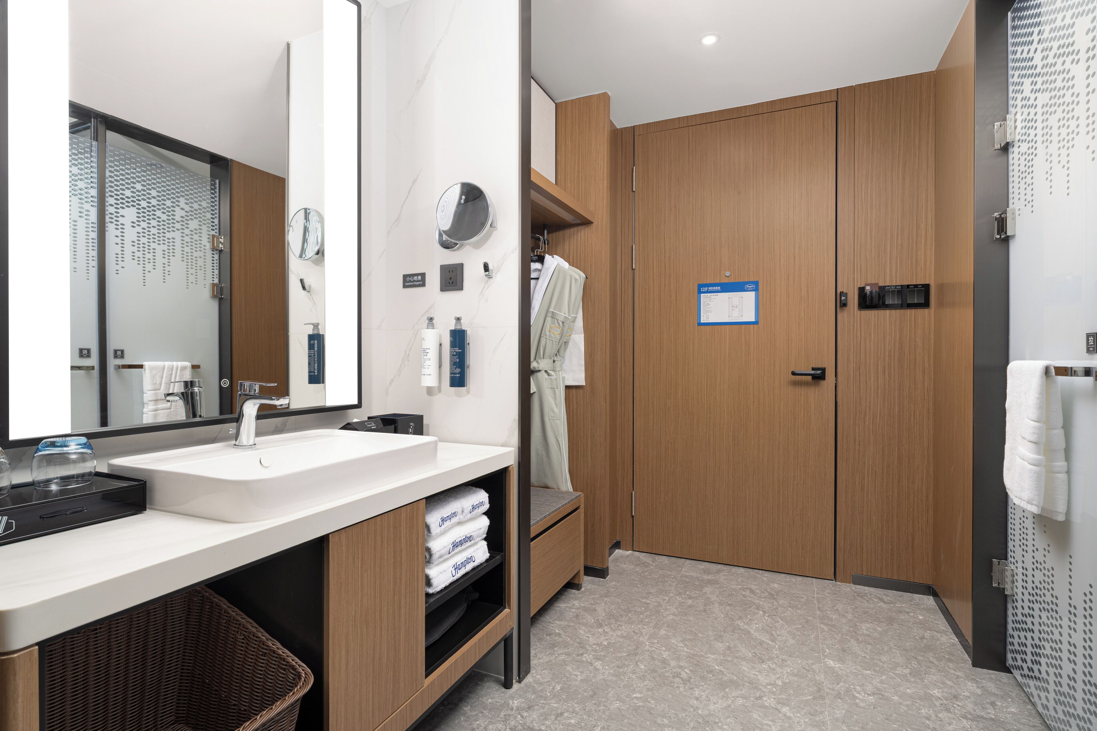 Un baño moderno con un espejo grande, un lavamanos y armarios de madera.