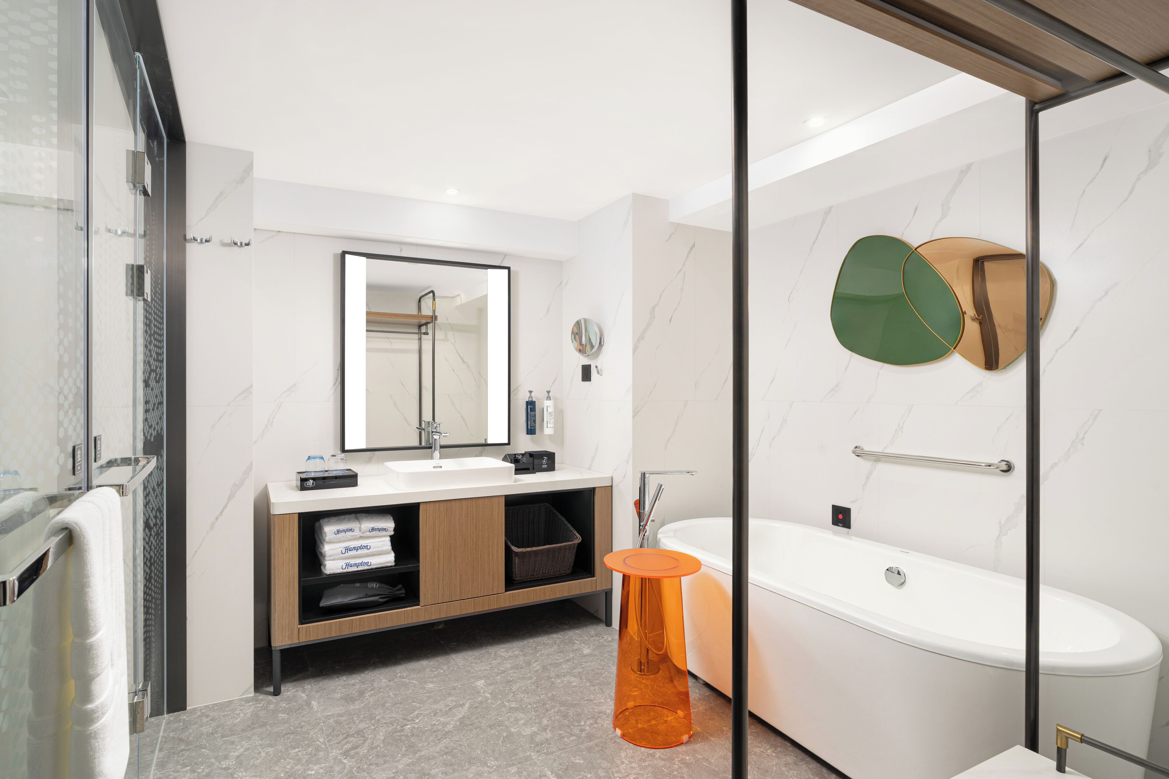 Une salle de bain moderne avec une douche à parois de verre, une baignoire blanche et un meuble-lavabo en bois avec un miroir.